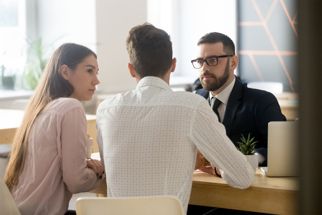 Young couple at desk with a mortgage representative
